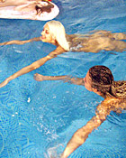 Two teenage girls having fun with their own blowup doll