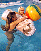 Two teenage girls having fun with their own blowup doll
