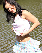 A hot naked chick posing on a boat in the water for camera