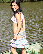 A hot naked chick posing on a boat in the water for camera