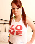 A very hot teenage redhead with massive titties on her bed
