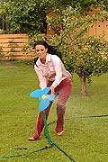 Two hot lesbian babes playing with a garden hose outside
