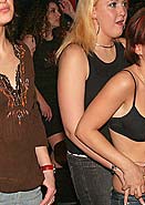 Cute brunette babe sucking on two hard cocks at a party