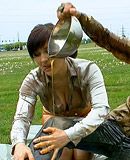 Two cute clothed hotties playing with liquid food outdoors