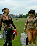 Two cute clothed hotties playing with liquid food outdoors