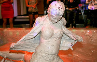 Two sexy cuties publicly playing in a big tub of dirty mud