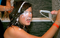 Two horny lesbians at a large sex party playing with cream