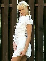 Blonde cutie flirtatiously undresses and poses in garden