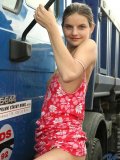 With her hair tied back carolina poses outside infront of a big ass mack truck ooh small boobies