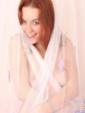 Red head hottie smokie covers herself in a sheer veil from the bed nude underneath