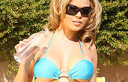 Check out Brea Lynn, in her blue micro bathing suit, taking in the rays and rubbing oil all over herself!